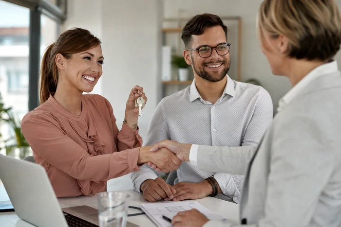 Woman handing over house keys at closing